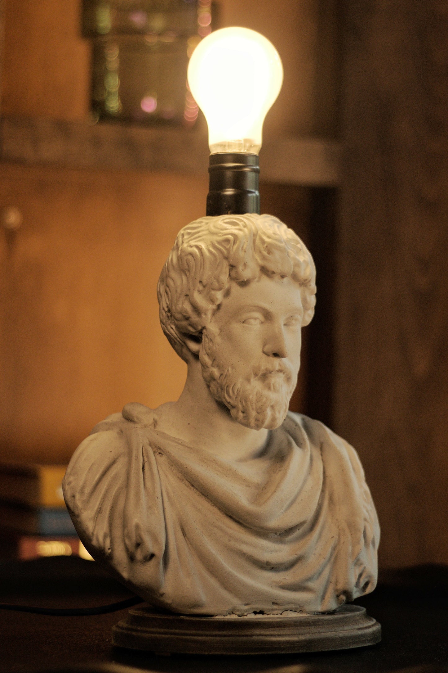 Statue head with a light bulb on top in a warm-toned room